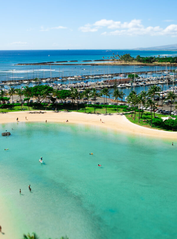 Turquoise water touches golden shores where people rest